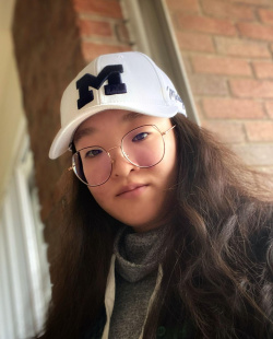 Portrait photo of team member Zhou, Xu wearing a white University of Michigan hat