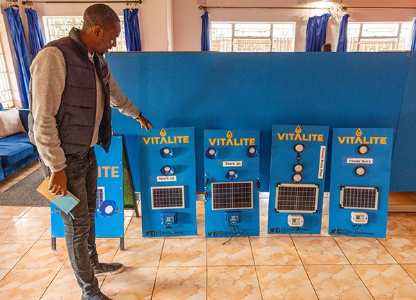 A representative of VITALITE, a social enterprise selling solar products, shows off solar home systems for sale on a pay-as-you-go basis in Lilongwe, Malawi. There are approximately 20 social enterprises selling similar systems in Malawi.
