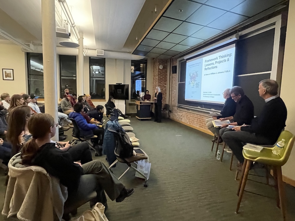 A photo of the room where the book talk took place, showing the front rows of the audience members listening to Joan Nassauer introduce Har Ye Kan