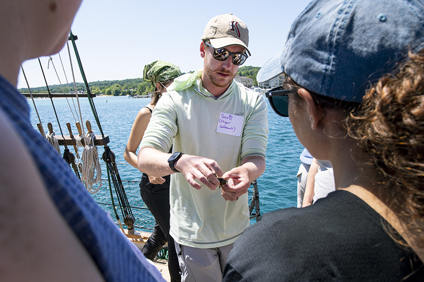 a SEAS PhD student shows two students a fish