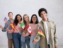 5 students holding small flags from different countries