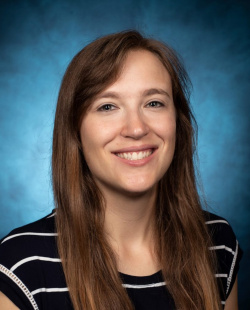 Portrait photo of team member Laura Gumpper with a blue background