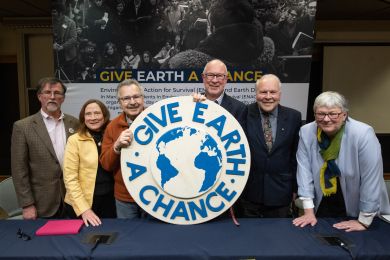 From left, panelists George Koling, Elizabeth Grant Kingwill, Doug Scott, David Allan, Arthur Hanson and Barbara Alexander pose with the emblem from the original 1970 Teach-In on the Environment. (Photo by Dave Brenner, School for Environment and Sustainability)