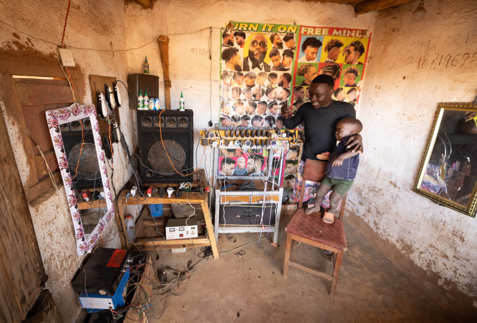 Solar technologies provide a source of electricity for small businesses in trading centers. This entrepreneur uses solar panels and batteries to power his haircutting and phone charging business in rural lilongwe district.