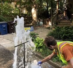 University of Michigan doctoral student Matthew Vedrin (MS &#039;16, PhD &#039;22) and city colleagues (not shown here) sample water for testing during routine summer flushing