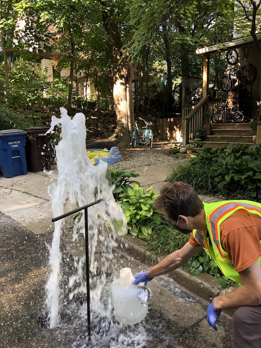 University of Michigan doctoral student Matthew Vedrin (MS &#039;16, PhD &#039;22) and city colleagues (not shown here) sample water for testing during routine summer flushing